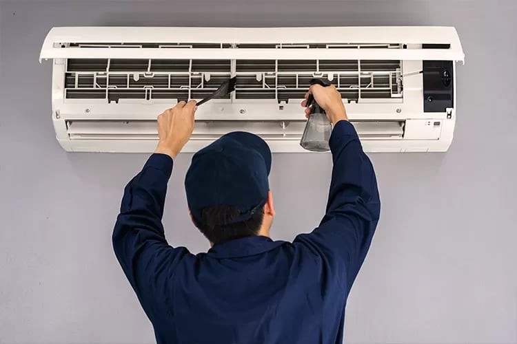 State-licensed technician servicing rooftop AC